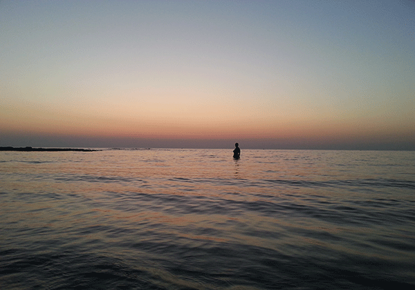 Bagno durante un suggestivo tramonto, spiaggia Rivabella Gallipoli