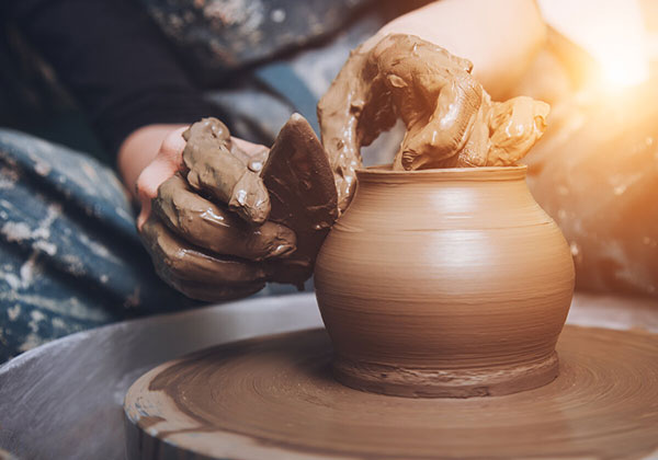 Abili mani lavorano al tornio un vaso in terracotta salentina.