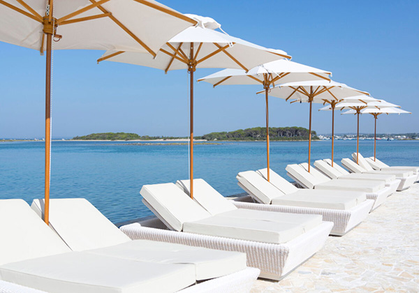 Bellissima immagine degli ombrelloni e lettini con sullo sfondo l'isola dei Conigli , dal "Beach Club Isola", Porto Cesareo, Lecce.