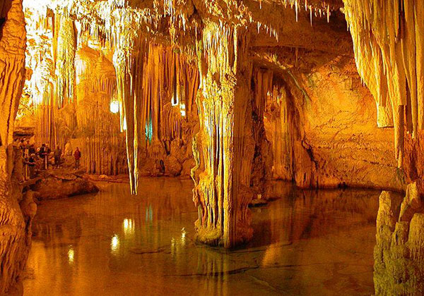 Grandissima caverna, e si può vedere quanto sia grande dalla dimensione dei visitatori in fondo ad essa, con stalattiti e stalagmiti. Grotta della Zinzulusa, Castro, Lecce.