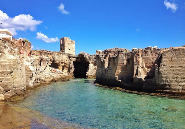 Scogliera a picco sul mare ed un mare limpidissimo fanno da cornice alla Torre Costiera di Tricase Porto, Lecce.