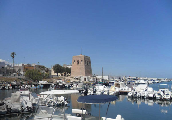 Barche ormeggiate con sullo sfondo la Torre Costiera. Porto di San Foca, Melendugno, Lecce.