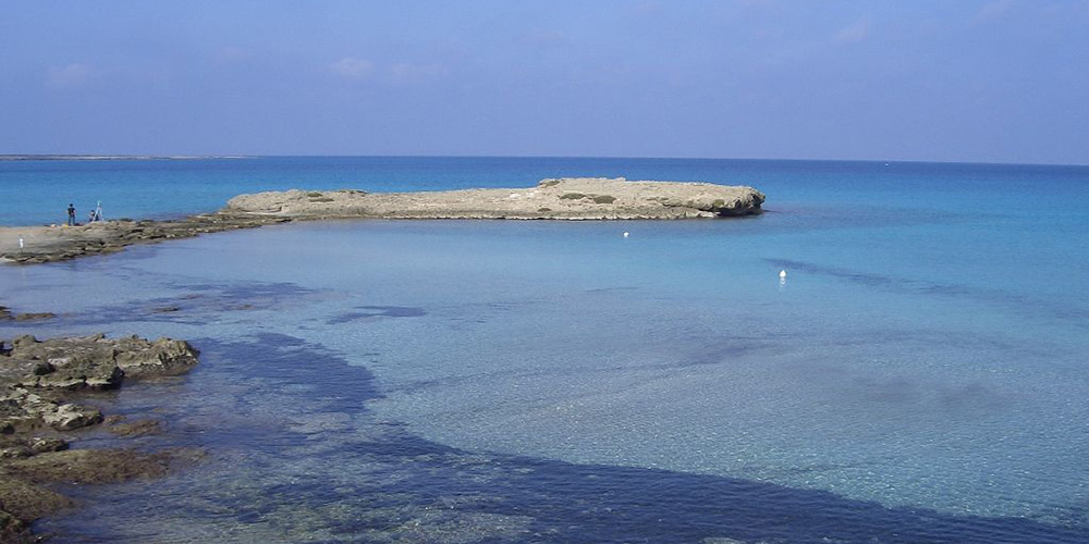 Acque limpidissime e lo scoglio che si inoltra nel mare questa spiaggia è "Punta della Suina", Gallipoli, Lecce.