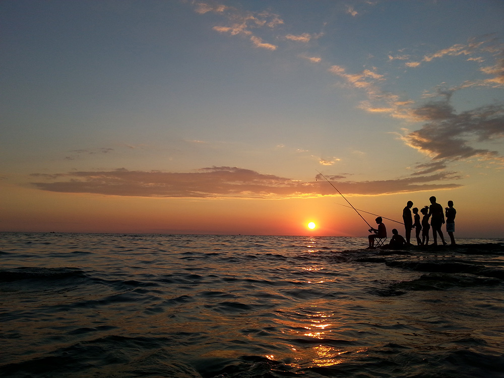 Al tramonto bambini che pescano, Rivabella, Gallipoli, Salento, Lecce. Contattaci Pianifica la Tua Vacanza nel Salento.